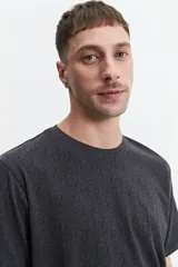 Remera de manga corta color crema con estampado abstracto en blanco, de corte recto y cuello redondo.