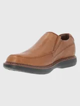 Zapato de vestir color marrón, sin cordones, de cuero vacuno liso. Tiene elásticos laterales, plantilla de cuero y algodón orgánico, y suela de goma EVA.