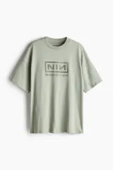 Remera verde con estampado del logo de la banda Nine Inch Nails y el nombre de su álbum The Downward Spiral.