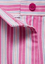 Falda midi de corte recto con estampado de rayas verticales rosas y blancas. Tiene abertura frontal, cierre con cremallera y botón, bolsillos laterales y traseros.