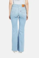 Pantalón de jean celeste con corte flare y diseño de parches en diferentes tonos de azul.