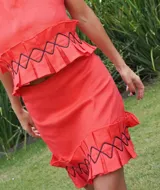 Pollera corta color marrón rojizo, con textura arrugada y volados en el ruedo. Presenta detalles de costura negra en zigzag sobre los volados.