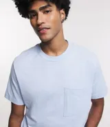 Remera celeste de media malla, corte comfort, cuello redondo, manga corta y bolsillo en el pecho.