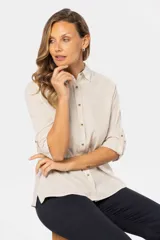 Camisa color beige de lino, de manga larga con botones para sujetar las mangas arremangadas y botones personalizados.