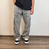 Pantalón jean color beige, corte recto y estilo cargo con bolsillos laterales.