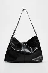 Bolso shopper negro de charol con asa de hombro ajustable, bolsillo interior con cremallera y cierre magnético.