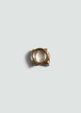 Set de tres anillos de metal con diseño geométrico: uno dorado con forma cuadrada, uno plateado con forma circular y uno plateado con forma cuadrada.