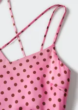 Vestido midi de satén rosado con estampado de lunares marrones, tirantes finos cruzados en la espalda y espalda descubierta.