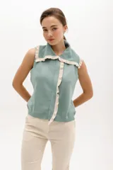 Chaleco color verde agua de tejido de punto, con cuello polo y cierre frontal con volados color crema.