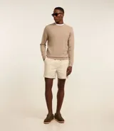 Suéter de punto color borgoña, con cuello redondo, sisas ligeramente desplazadas y bajo y puños acanalados.