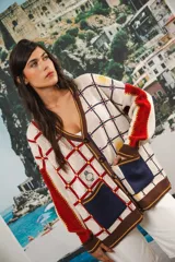 Cardigan oversized de tejido jacquard color crema con diseño de cuadrados en marrón y detalles bordados. Tiene cuello en V, cierre con botones, mangas largas y bolsillos frontales.