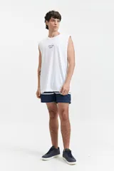 Musculosa negra de algodón con corte oversize y estampado en turquesa en la espalda con la frase "Good things Never come from Comfort Zones" y el logo de la marca Mistral.
