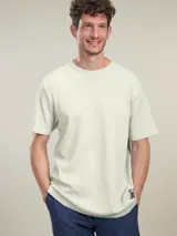 Remera de manga corta color azul marino, con cuello redondo y textura acanalada. Presenta un pequeño logo bordado en la parte inferior del ruedo.