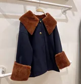 Sobre camisa azul marino con cuello y puños de cuero de cordero color óxido.