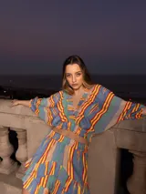 Top corto con escote en V y mangas cortas amplias, con estampado de rayas verticales en tonos celeste, amarillo, rojo y verde.