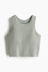 Top deportivo corto color verde claro, de tejido acanalado con tecnología DryMove™ para absorción de humedad. Tiene breteles anchos, copas forradas con relleno extraíble y elástico ancho en el bajo.