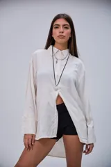 Camisa de manga larga color beige, con cuello clásico y botones frontales.