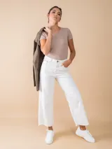 Jean ancho color crudo con corte recto, tiro alto y ruedo deshilachado.