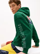 Buzo verde con capucha y cordón distintivo, bolsillo canguro, puños y bajo de punto canalé, logo oversize de Tommy Hilfiger en la manga y la parte trasera, parche con logo de Tommy Hilfiger en el pecho y detalles distintivos de Hilfiger Sailing.
