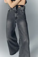 Jean oxford tiro alto de denim negro con lavado stone y bigotes. Pierna ancha desde la cadera.