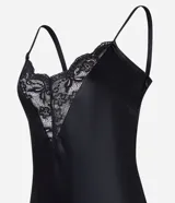 Vestido midi negro de satén con breteles finos y escote en V con detalle de encaje en el busto.