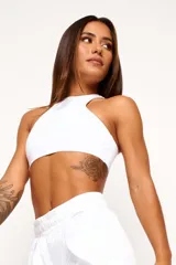 Top deportivo blanco de cuello alto, sin mangas y corte ajustado.