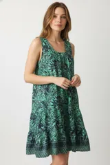 Vestido corto de poliéster con estampado floral en tonos verde y azul, corte suelto y cuello redondo.