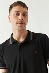 Chomba azul marino de manga corta con cuello polo y detalles de líneas grises en cuello y mangas. Tiene logo bordado en el pecho. Corte regular.