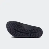 Sandalias tipo ojota negras con tira brillante y suela gruesa con tecnología de absorción de impacto y soporte de arco.