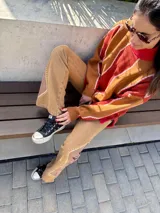 Buzo de tejido color rojo y marrón con diseño geométrico, de fit oversize.