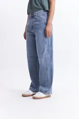 Pantalón jean celeste de tiro medio, corte amplio y redondeado.