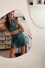 Top corto verde azulado de cuero ovino vintage, con cuello halter y espalda descubierta. Se cierra en la espalda con una hebilla metálica.