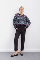 Pantalón negro de tiro alto con elástico interno en la cintura, botones falsos y terminación con volado. Tiene bolsillos aplicados en delantero y falsos en espalda.