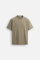 Camiseta color caqui de corte cuadrado, confeccionada en tejido de algodón pesado. Tiene cuello redondo y mangas cortas.