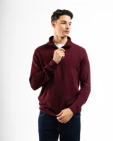 Sweater verde de punto con cuello alto y cierre medio con cremallera.