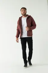 Campera de felpa color bordó con capucha y cordón ajustable, cierre frontal con cremallera, bolsillos laterales y logo estampado en el pecho.