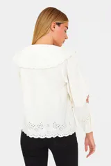 Camisa celeste de algodón con bordados florales, cuello babero con volados y lazo.