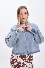 Campera de jean celeste, corte cropped, con cuello clásico, cierre frontal con cremallera, mangas largas con puños elásticos y bolsillos laterales.