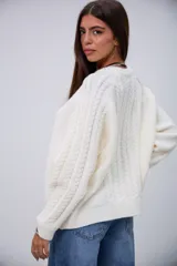 Sweater blanco de punto trenzado, con cuello redondo y mangas largas.