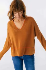 Sweater beige y azul con cuello en V y ribete bordeaux.