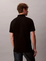 Chomba negra de piqué de algodón, corte clásico, cuello tradicional y tapeta de botones. Logo de Calvin Klein bordado en el pecho.