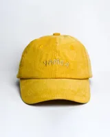Gorro de pana color mostaza con visera y bordado frontal con la palabra "Yamba".