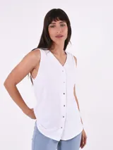 Camisa blanca sin mangas con cuello en V y cierre frontal con botones.