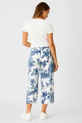 Pantalón capri blanco con estampado floral azul, de algodón y calce holgado.