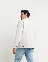 Campera de hombre color beige con cierre frontal, cuello camisero y bolsillos laterales. Corte clásico.