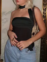 Top strapless negro con detalle drapeado en el busto y un tirante ancho que se extiende desde el escote hasta el hombro.