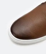 Championes slip on marrones de cuero, con talón flexible y suela blanca.