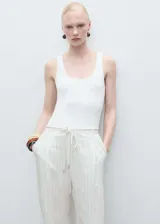 Mono largo de tejido mezcla de lino a rayas verticales, con tirantes finos, escote recto, cinturón tipo lazo en la cintura y bolsillos laterales.