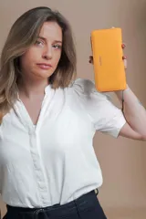 Billetera larga color beige de símil cuero, con cierre perimetral y bolsillo trasero con cierre.