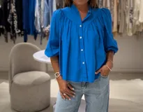 Camisa azul francia de manga larga con puño, cuello mao y cierre frontal con botones.